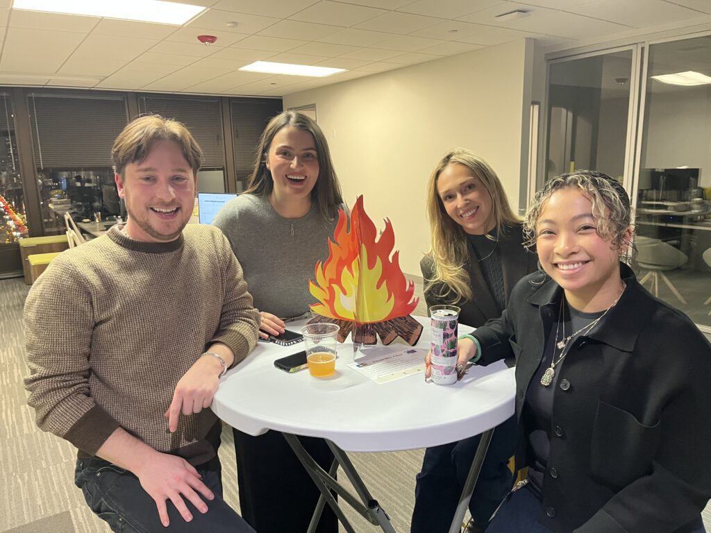Employees standing at a table at a company holiday happy hour